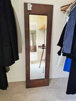 Full front view of the vintage full length wall mirror showing the wooden frame and mirror glass.