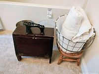 Photo of vintage shoe shine box, metal bin, clear container, wooden stool, and wire basket with white towels.