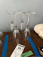 Four clear Baccarat crystal champagne flutes shown upright upside down on a wooden surface with a label identifying them as Baccarat champagne flutes