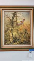 Framed original canvas painting showing two pheasant-like birds flying in a natural forest scene with warm earthy colors.