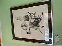 Framed and matted black and white print depicting two swans or water birds with reeds.