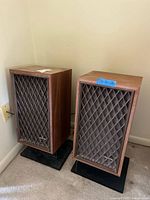 Pair of vintage Realistic speakers mounted on black stands, shown from front angle.