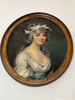 Front view of the oval framed portrait painting showing the woman in white dress and powdered hair.