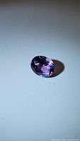 Close-up photo of the natural purple amethyst oval cut gemstone showing the rich purple color, cut, and clarity.