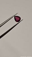 Close-up view of the faceted deep red pear cut ruby showing clarity and natural inclusions.
