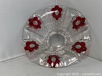 Top view of clear glass bowl showing six red flower motifs