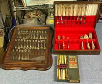 Wooden silverware chest with partial set of ornate EPNS cutlery, framed collector spoon display, and boxed Sheffield table knives.