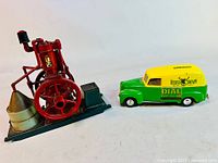Lot showing both Ertl diecast Deere Company utility van and stationary steam engine models on a white background.