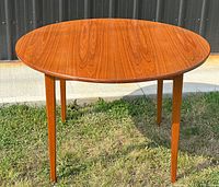 Angled front view of table without leaves attached, showing overall shape and finish