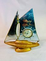 Full view of vintage sailboat clock showing gold-tone base with silver-tone sail, clock mounted in center.