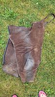 Both chaps laid flat showing suede leather, zipper sides and wear