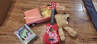 Group shot showing Barbie car, ukulele, Cabbage Patch Kid, My Little Pony box