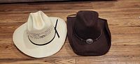 White Bangora and brown Rodeo cowboy hats on floor