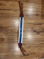 Full view of girth front side showing blue stripe and leather ends