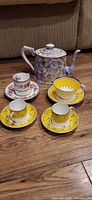 Group shot showing teapot and all four cup and saucer sets