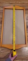 Full view of honey wood calendar frame with tape showing overall height of about 27 inches