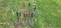All ten metal racks and holders laid out on grass
