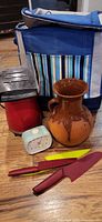 Group shot showing popcorn maker, alarm clock, ceramic pot, knives and picnic cooler
