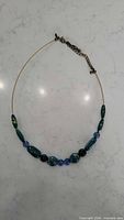 Blue and green bead necklace on thin wire