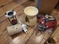 Four warmers including metal stand, ceramic plug-in, ceramic bowl-top, and packaged ladybug warmer