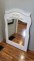Front view of full mirror showing white MDF frame and scroll crown