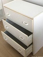 Front view of the white wood dresser with all three drawers open, showing drawer interior space and pull handles.