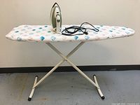 Side view of ironing board with Black & Decker iron resting on top, cord wrapped around the iron base.