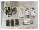 Photo showing multiple packaged hardware items including door knobs, hinges, and cabinet handles in satin nickel finish.