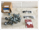 Photo showing 21 set screw connectors, some still in original packaging, alongside other hardware pieces.