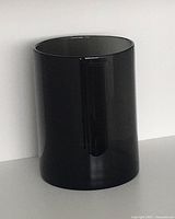 Glossy black glass vase with smooth cylindrical profile, slightly tapered outward at rim, shown against white background.