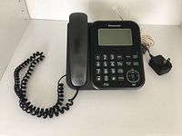 Front view of Panasonic KX-TG4771C corded digital phone with answering system, showing buttons, display, handset and power cord.