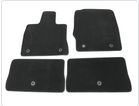 Two black carpet floor mats laid flat on a white surface showing top side with grommet holes and fitted shapes.
