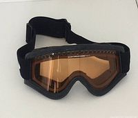 Front view of the black framed Oakley goggles with amber tinted lens and adjustable strap visible.