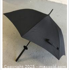 Closed view of black umbrella with samurai sword-style handle and wrist strap.