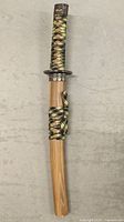 Full sword with wooden sheath, black and yellow cord wrapping, viewed from top to bottom
