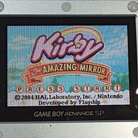 Game Boy Advance SP screen showing the Kirby & The Amazing Mirror title screen stating 2004 HAL Laboratory, Inc. / Nintendo developed by Flagship.