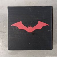 Top of the black box with a red bat silhouette logo representing Batman