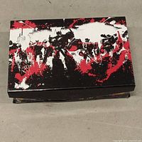 Closed collectible box with black, red, and white Transformers character art on top