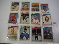 Overview of 12 vintage 1976 OPC hockey cards laid out on a surface.