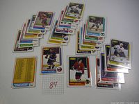 24 assorted 1986-87 O-Pee-Chee hockey cards arranged in groups on a white surface, showcasing front images of various players in NHL team uniforms with team logos and names.