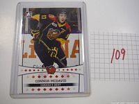 Front view of 2014 Connor McDavid hockey card from Canada's Best, showing player in Erie Otters uniform, inside protective sleeve.