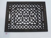 Overhead view of the antique cast iron grate with decorative lattice pattern and cross motifs.