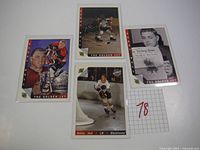 Photo of all four Bobby Hull hockey cards arranged flat on a white surface with a numbered paper '78'