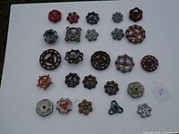 Top view photo shows all 25 vintage valve handles, assorted shapes and colors laid out on a white surface.