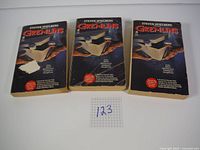 Front covers of the three Gremlins books by Steven Spielberg showing the box with Gremlin claw and title.