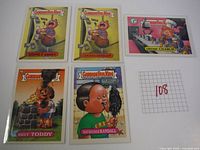 Five Garbage Pail Kids trading cards featuring Sidney Kidney, Locked Dorian, Chicken Charlie, Hot Toddy, and Ratsucker Randall displayed together.