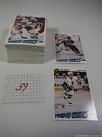 Stack of approximately 100 Young Guns rookie cards with two individual cards shown separately, front facing showing players in hockey uniforms.