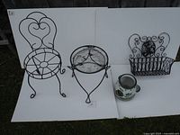 Photo showing two metal plant stands, ceramic herb pot, and metal wall basket against a white backdrop