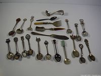 Full overview of 22 spoons including variety of souvenir, character, and serving spoons.