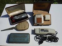 Overview of vintage personal care and sewing items including electric razor, clipper, sewing tin, hand mirror, and lotion bottle with box.